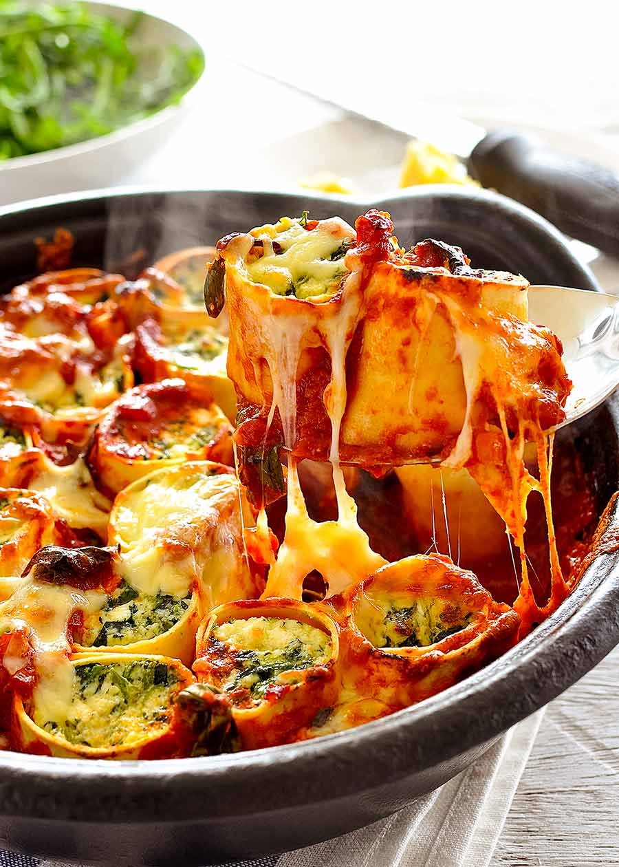 Spoon lifting up Spinach and Ricotta Rotolo - cheese pull!