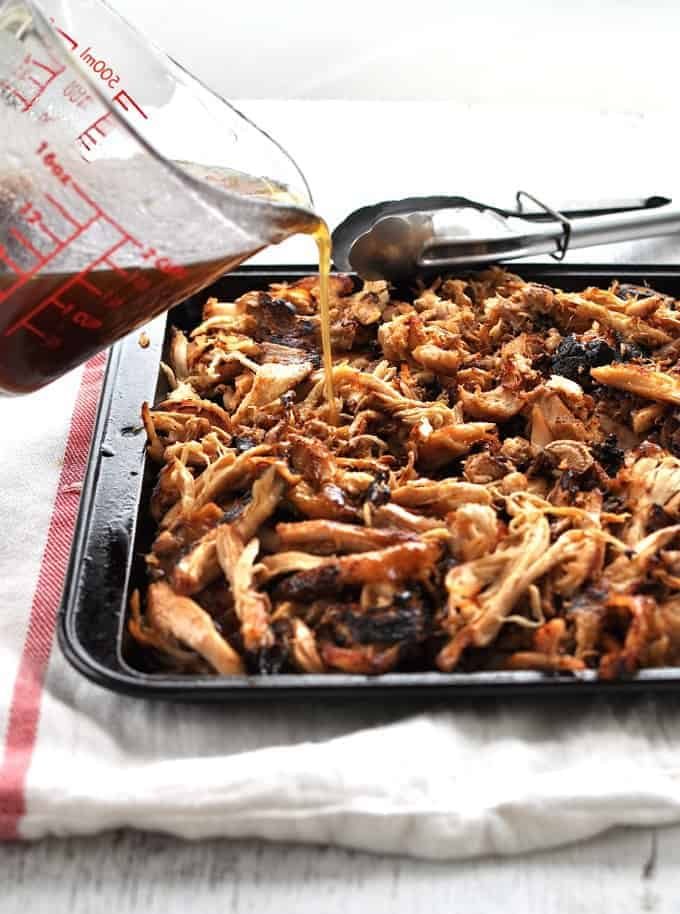 Braising liquid being poured over crispy Slow Cooker Chinese Shredded Chicken