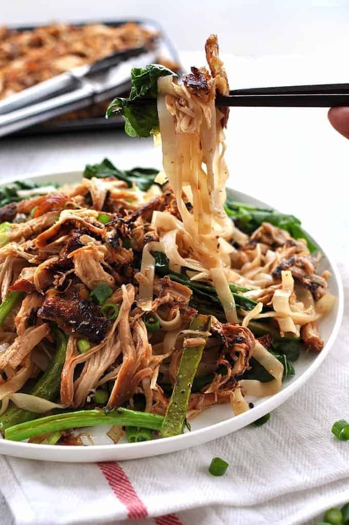 Chopsticks picking up Crispy Shredded Chicken Noodle Stir Fry from a plate.