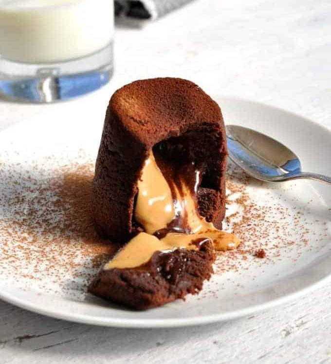 Peanut Butter Chocolate Molten Lava Cake cut open showing the molten peanut butter chocolate centre pouring out.