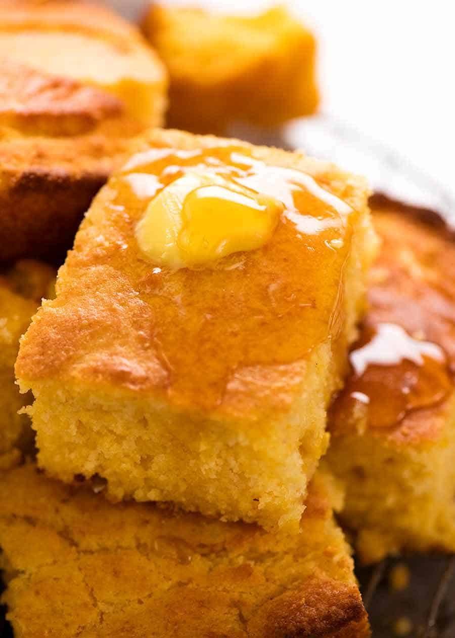 Close up of a piece of Cornbread with butter and honey