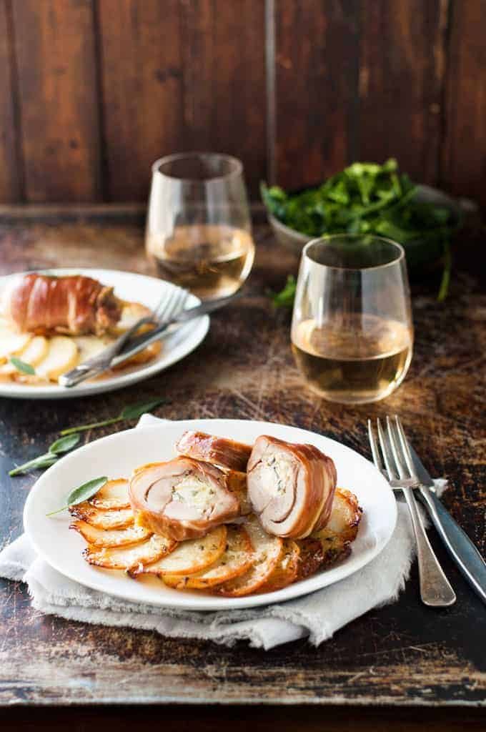 Prosciutto Wrapped Chicken and Scalloped Potatoes on a small white plate, ready to be eaten