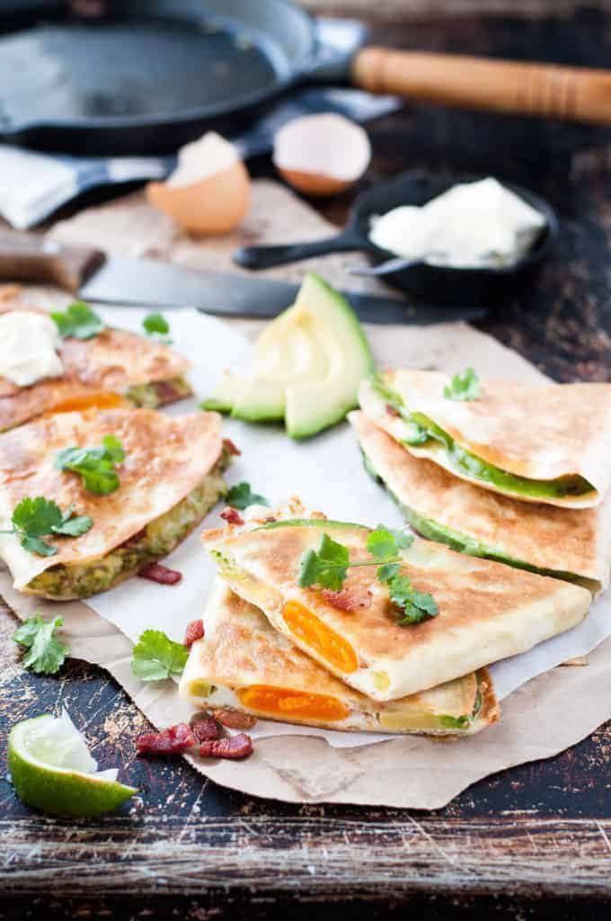 Sliced Egg, Bacon and Avocado Quesadillas with cilantro garnish