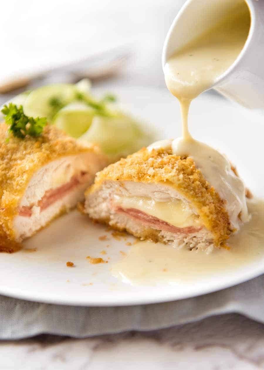 Dijon Cream Sauce being poured over Easy Chicken Cordon Bleu