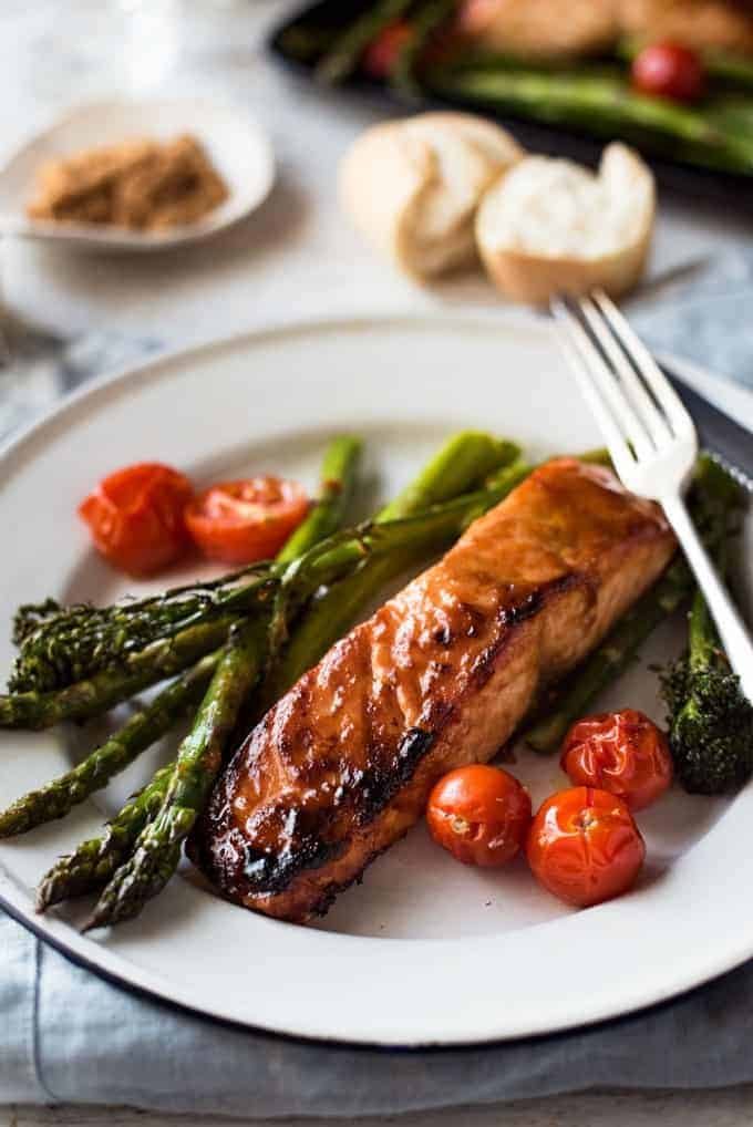 Spicy Brown Sugar Salmon on plate with asparagus and tomatoes