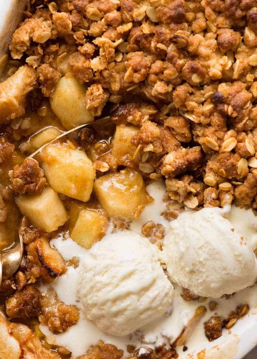 Close up overhead photo of Apple Crumble with scoops of vanilla ice cream