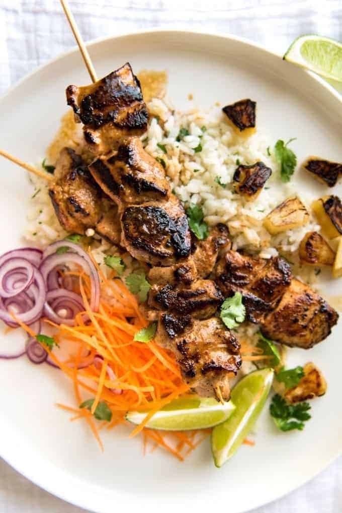 Coconut Cilantro Lime Rice on a plate topped with Hawaiian Coconut marinated Chicken Skewers.