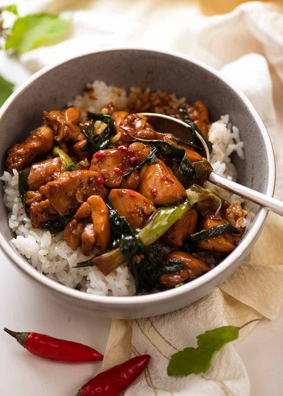 Thai Basil Chicken served over Jasmin rice in a blue bowl, ready to be eaten