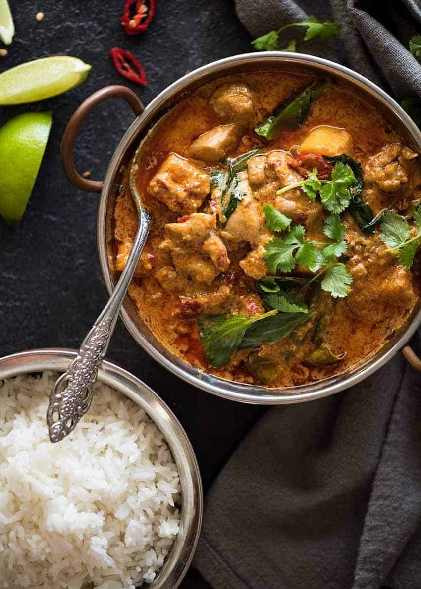 Thai Red Curry with Chicken in a serving bowl with a side of rice, ready to be served.