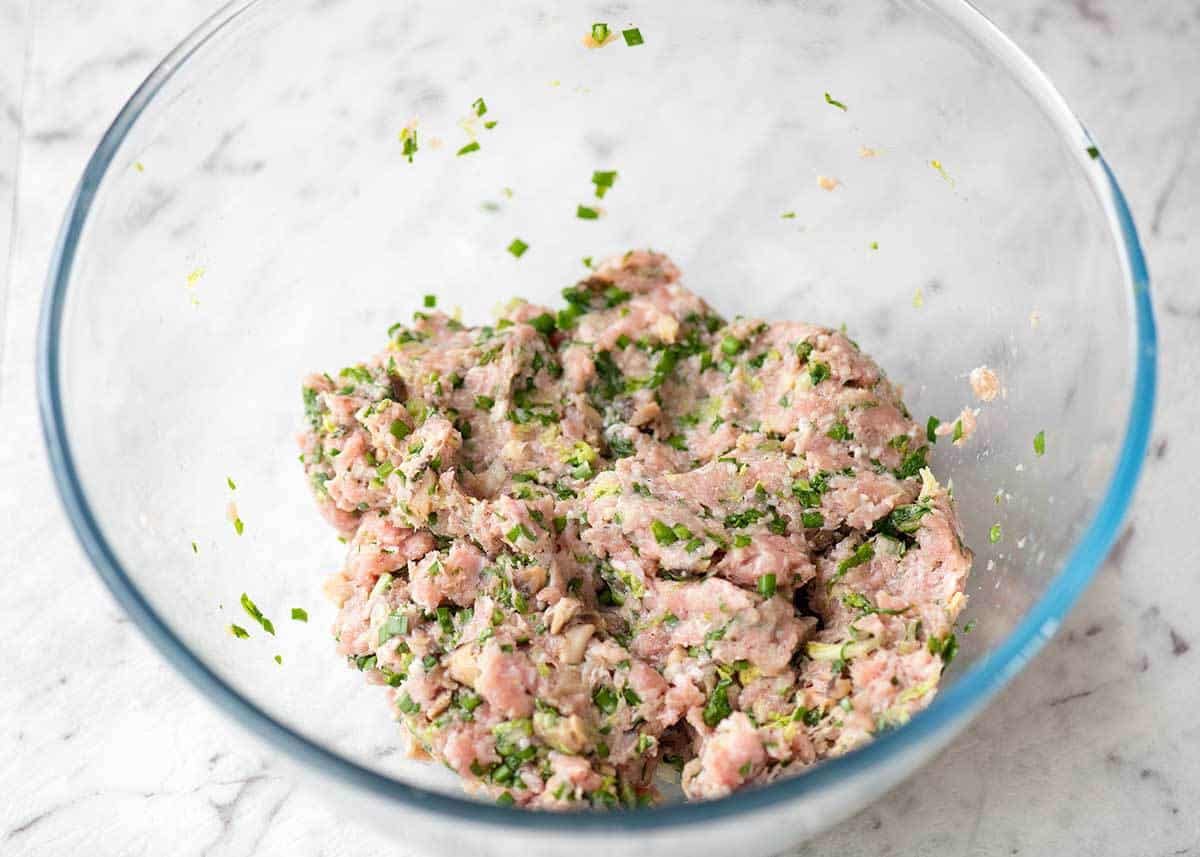 Glass bowl with Potsticker Filling made with pork, cabbage, shiitake mushrooms and chives.