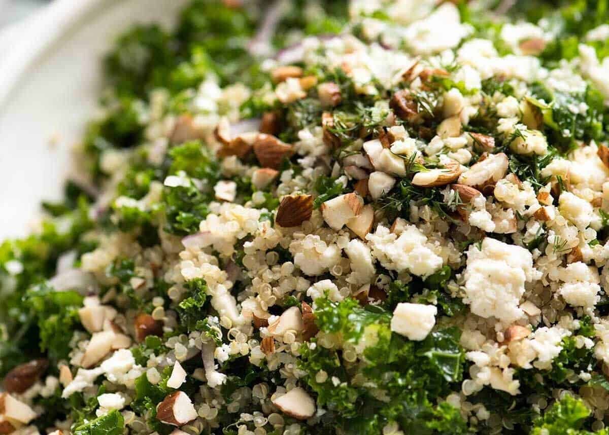 Close up of Kale and Quinoa Salad sprinkled with chopped almonds and feta