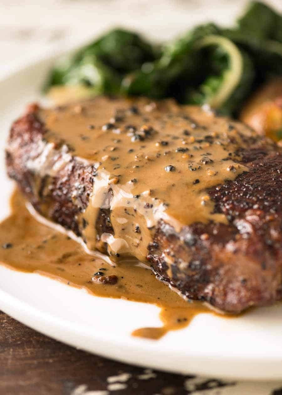 Close up of Creamy Peppercorn Sauce dripping down the side of steak