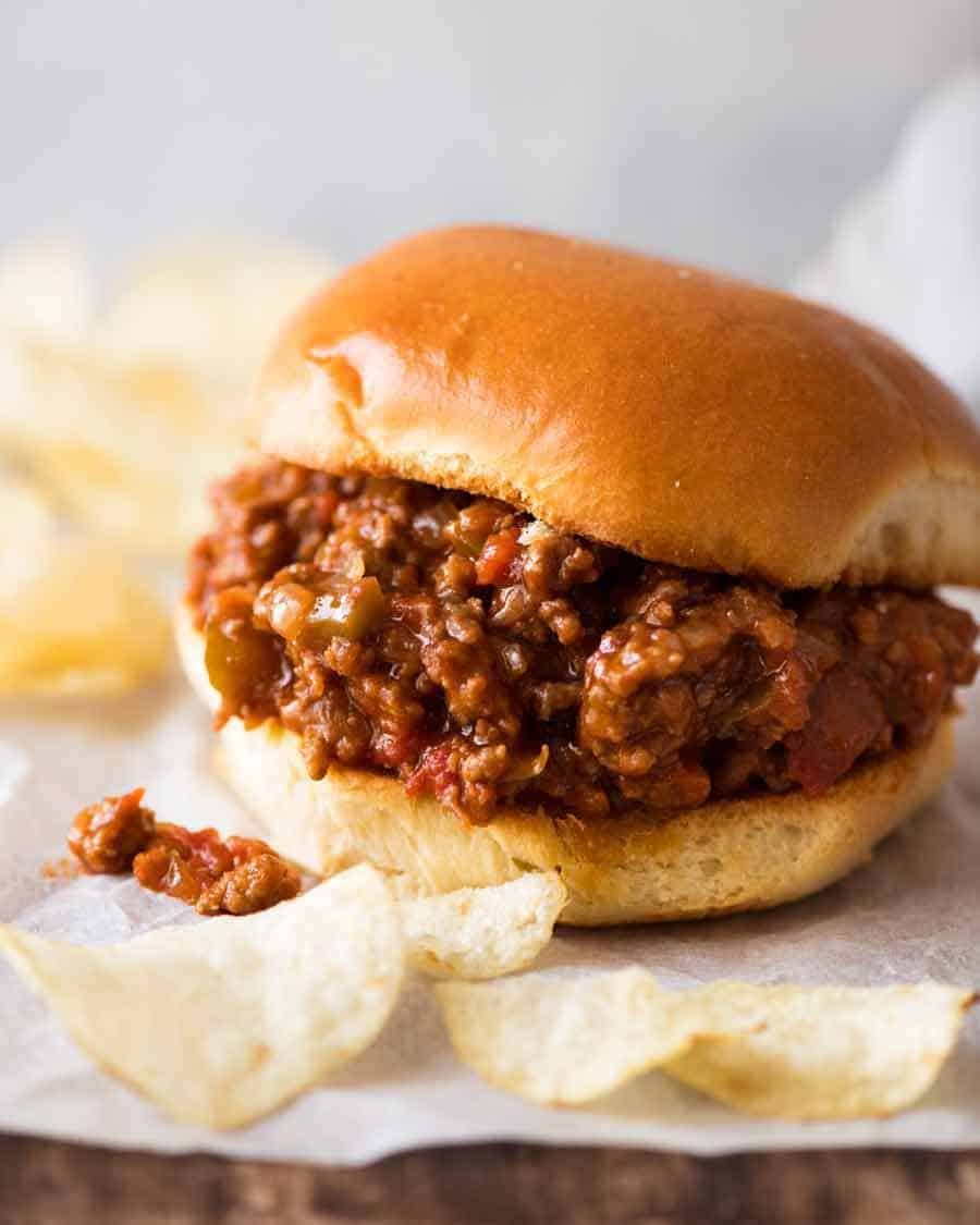 Close up of a Sloppy Joe with potato crisps on the side