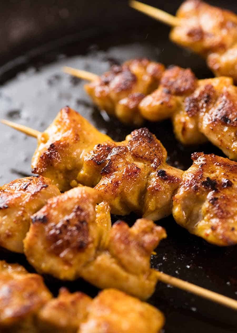 Thai Chicken Satay Skewers cooking in skillet
