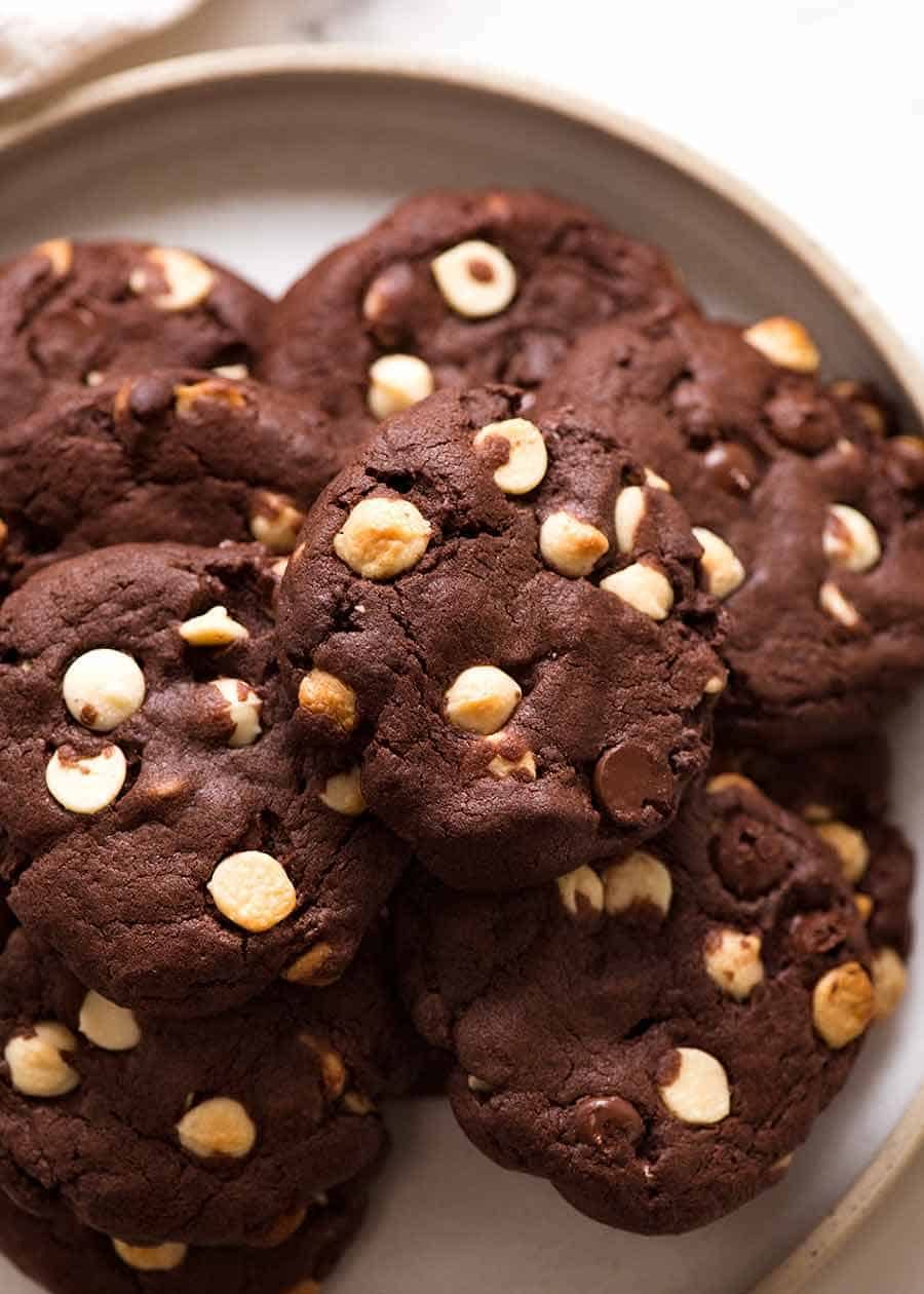 Pile of Triple Chocolate Cookies on a plate, ready to be eaten. Chewy on the inside, 40% chocolate, with crispy edges.