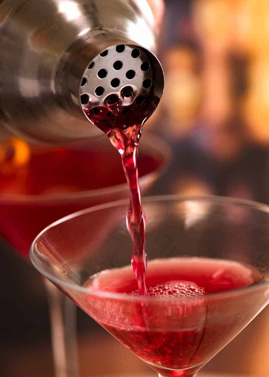 Pouring cosmo from cocktail shaker